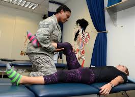 A picture of a woman stretching another woman's leg  